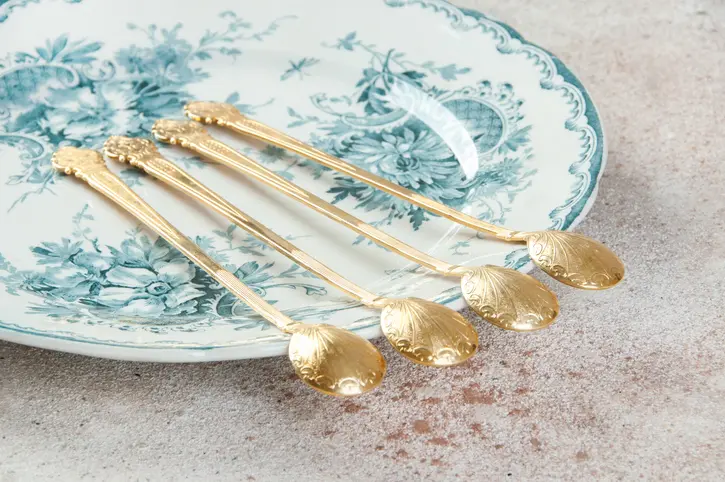 Antique metal cocktail spoons on old plate. Copy space for text, food photography props.